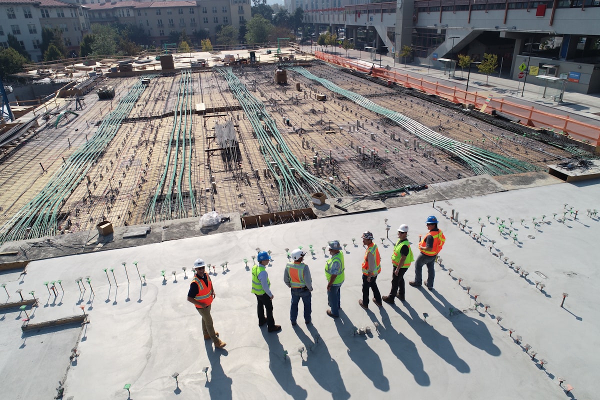 Construction professionals in safety gear reviewing work at a building site